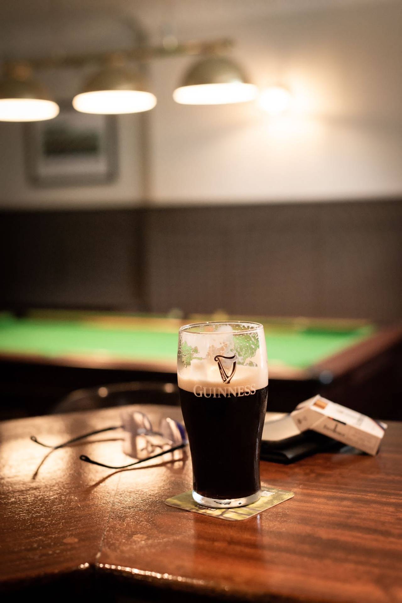 Pint of Guinness on the bar beside the pool table