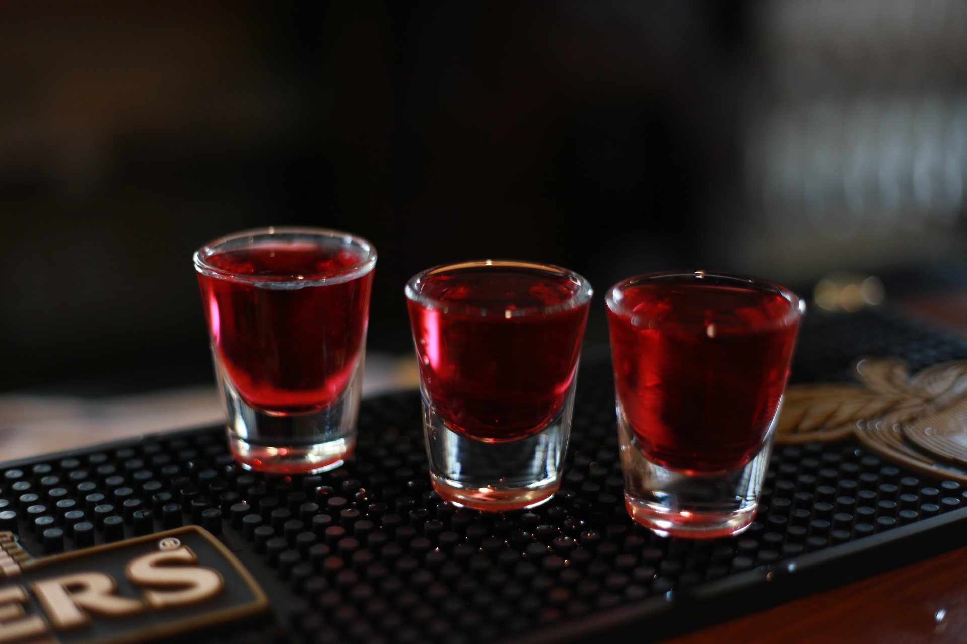 Three red shots on the bar mat
