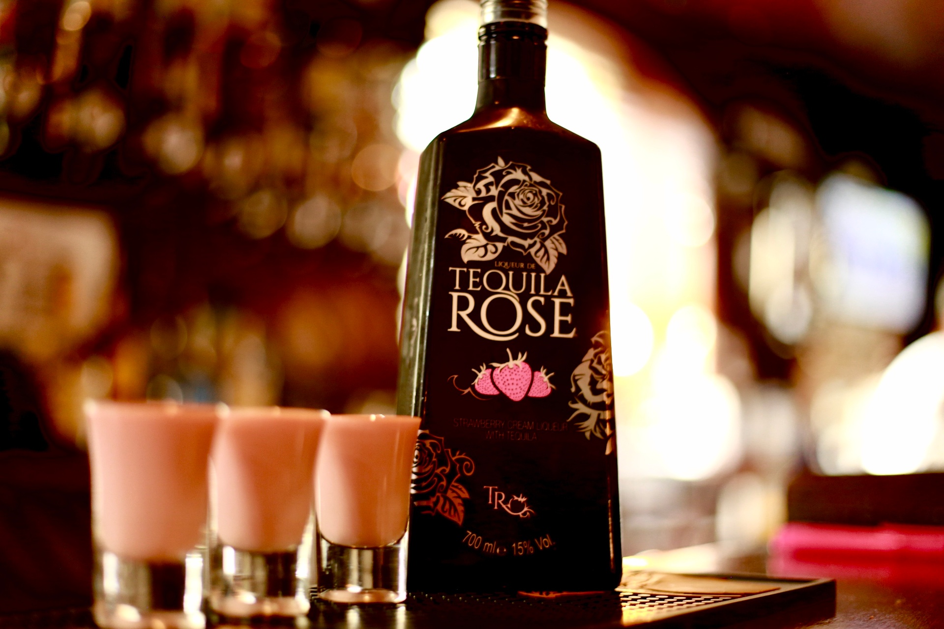 Tequila Rose bottle with three pink shots