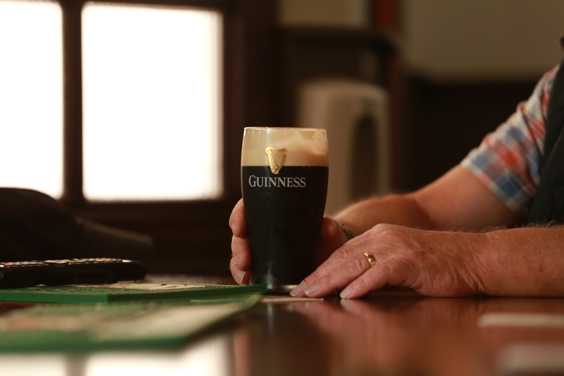 A pint of Guinness held at the bar